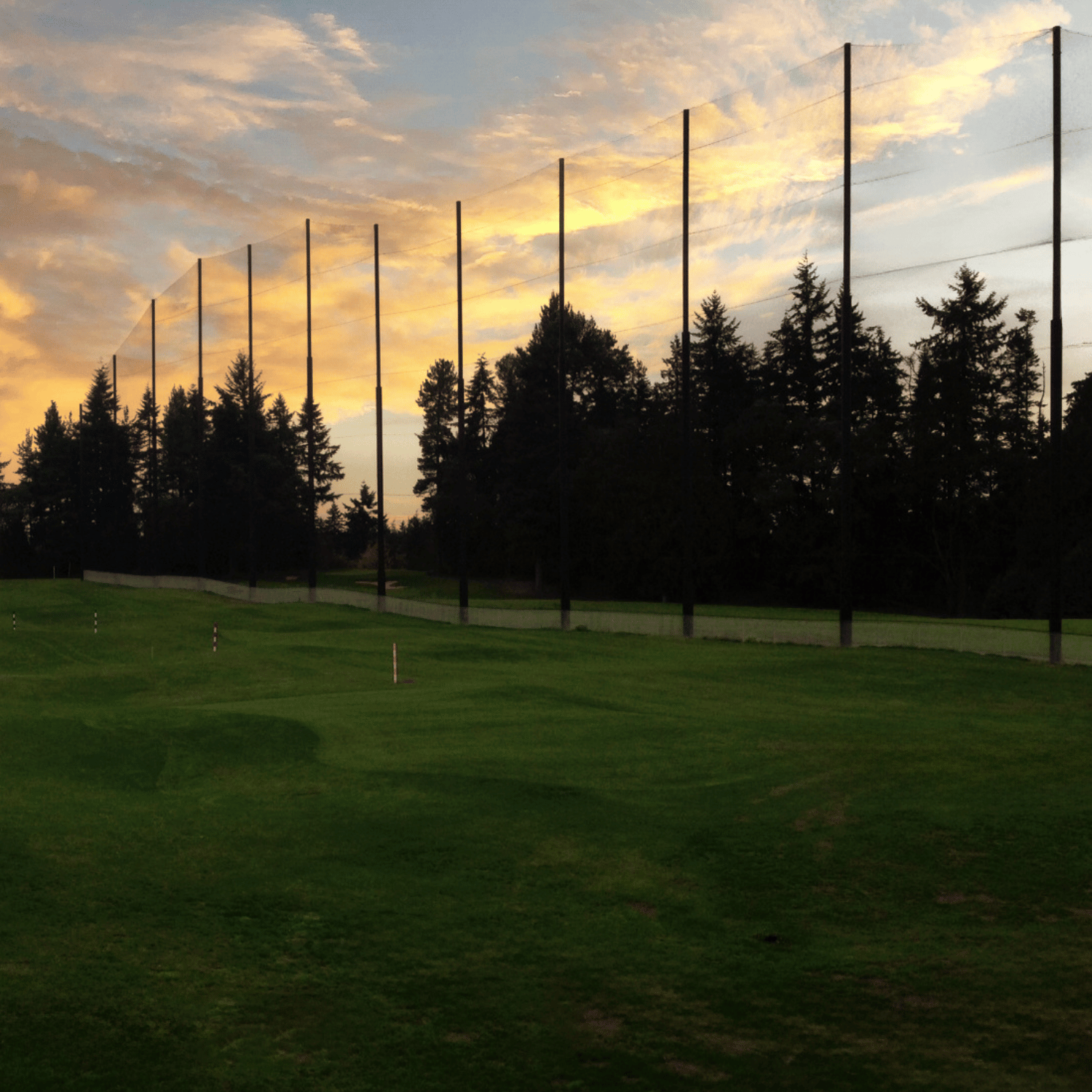 Sun setting at Jackson park golf course over the top of driving range nets
