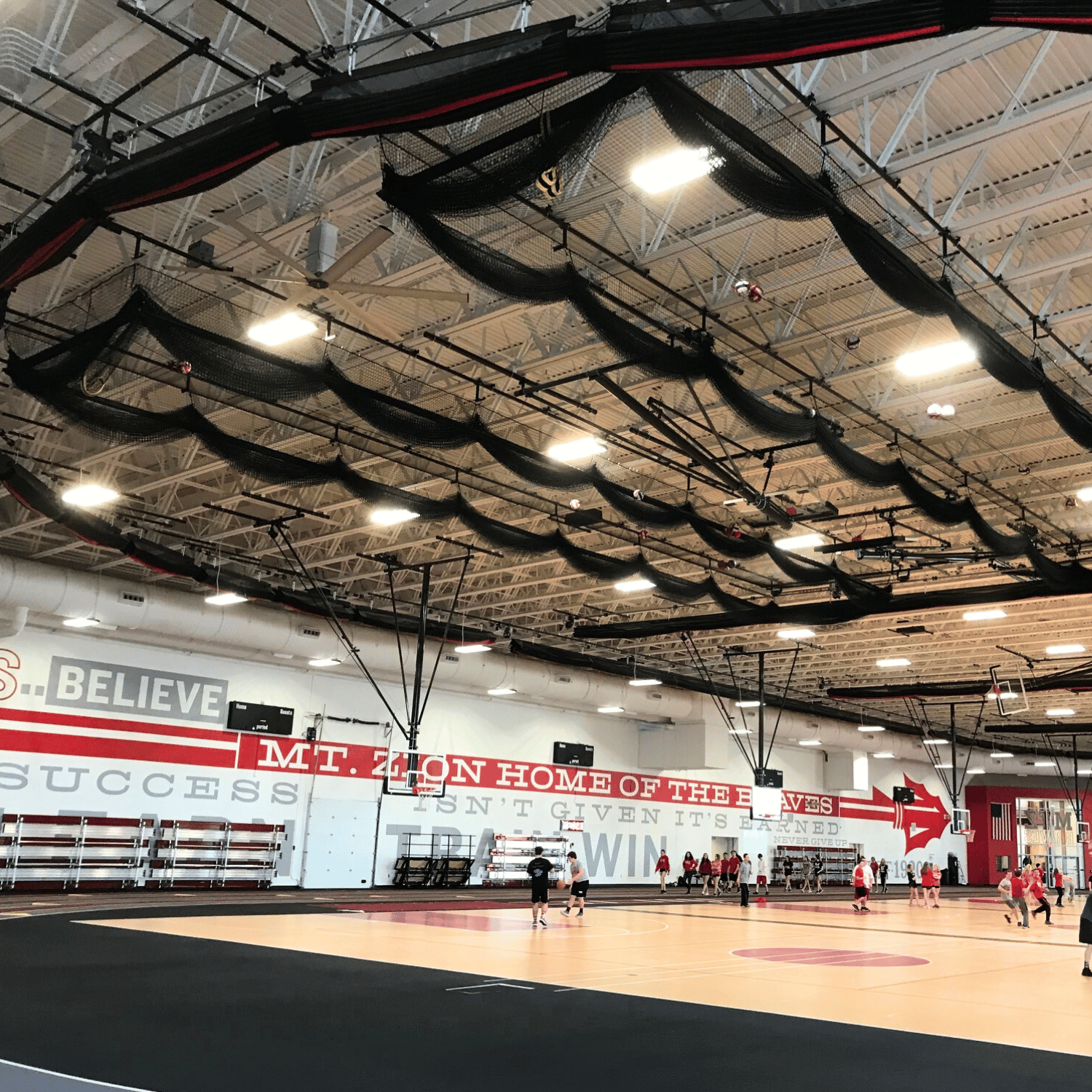 Gymnasium netting suspended from the ceiling in a high school gym.