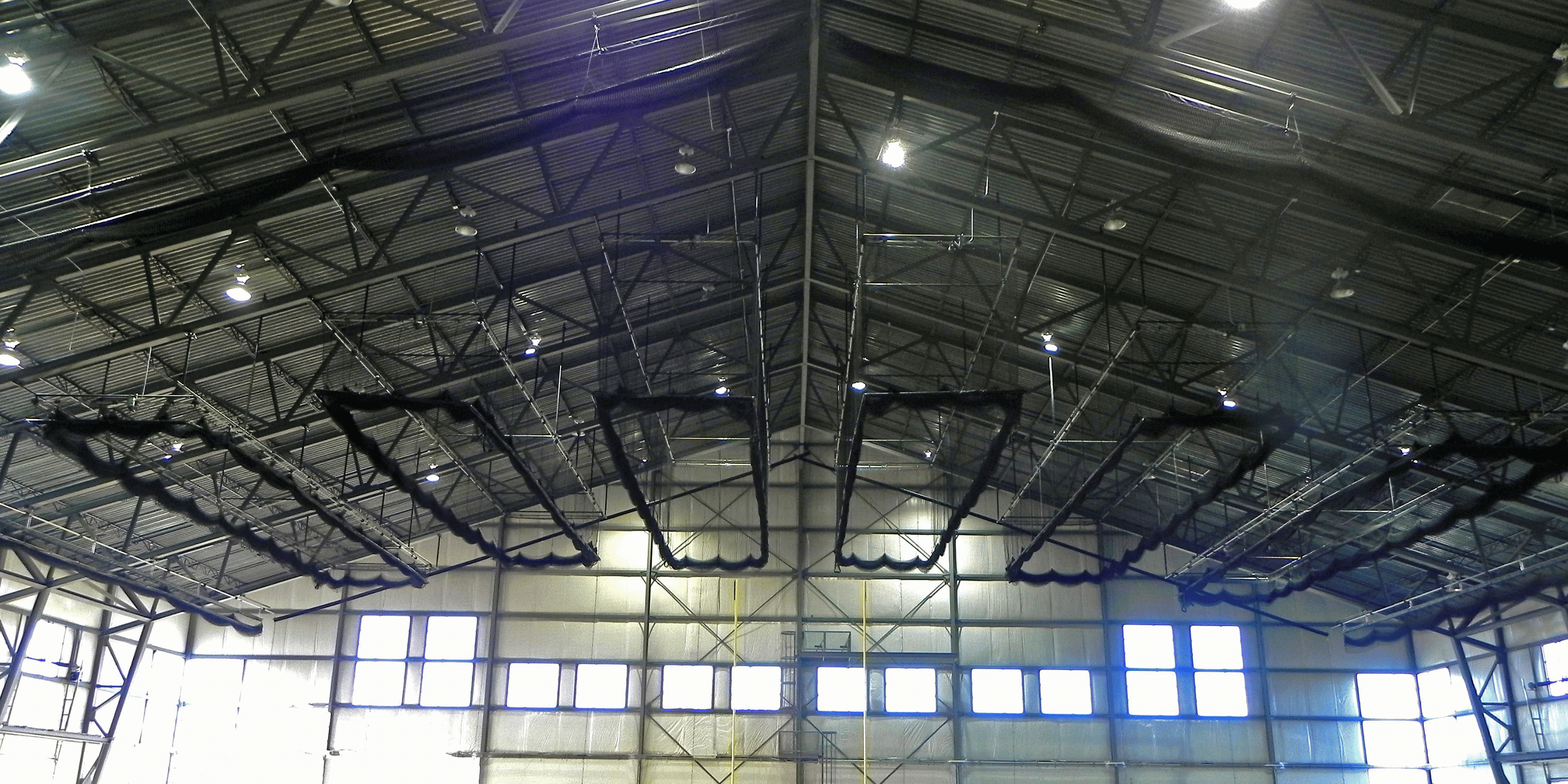 Indoor batting cage nets lifted up to the ceiling in sport complex facility. 