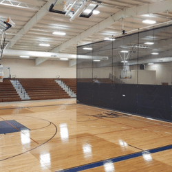 Gymnasium with dark navy blue divider curtain in the middle of the room.