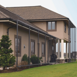 Brown home with protection netting in front 